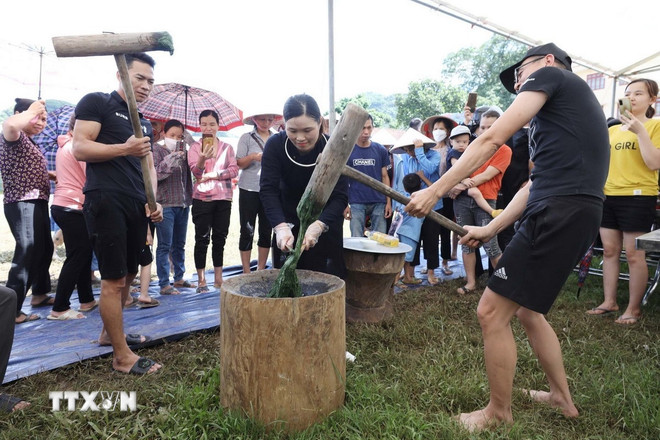 Wisatawan mencoba menumbuk kue beras di desa wisata Quynh Son, Lang Son. (Foto: Anh Tuan/VNA) ttxvn-2010-quynh-son-3.jpg