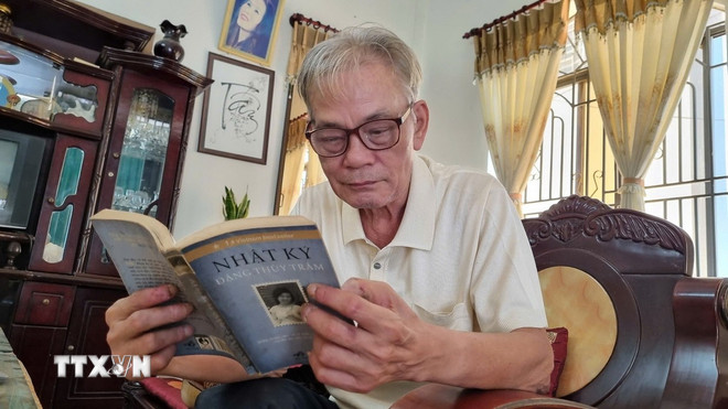 Ông Trần Đình Tâm (77 tuổi, nguyên lính Đại đội 120 đặc công huyện Đức Phổ), người từng được liệt sỹ, bác sỹ Đặng Thùy Trâm chữa bệnh, đang đọc Nhật ký của chị Trâm. (Ảnh: Đinh Hương/ TTXVN) ttxvn-1706-dang-thuy-tram-2.jpg