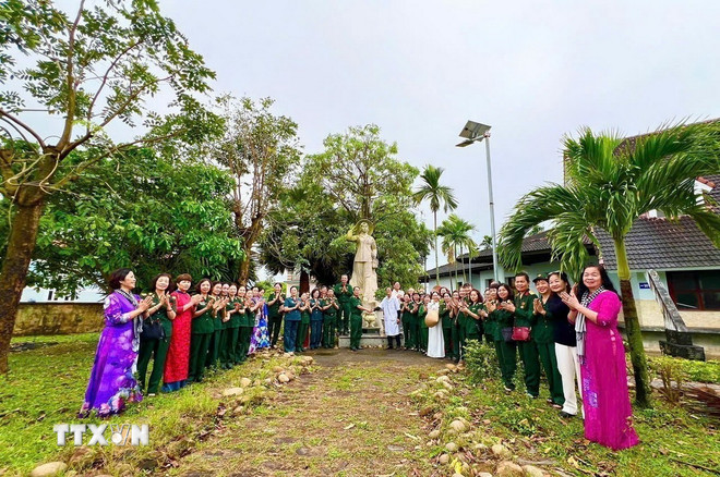 Du khách chụp ảnh lưu niệm tại khuôn viên Bệnh xá Đặng Thùy Trâm. (Ảnh: TTXVN phát) ttxvn-1706-dang-thuy-tram-4.jpg