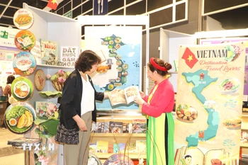 Du khách quốc tế tìm hiểu về văn hóa của Việt Nam tại triển lãm. (Ảnh: Xuân Vịnh/TTXVN)