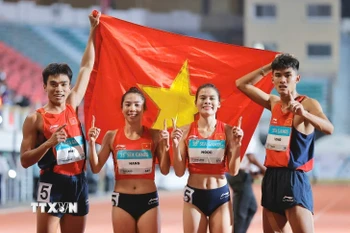 4 vận động viên Tạ Ngọc Tưởng, Nguyễn Thị Ngọc, Lê Ngọc Phúc và Nguyễn Thị Hằng giành HCV nội dung hỗn hợp nam nữ 4x400m, phá kỷ lục SEA Games. (Ảnh: Minh Quyết/TTXVN)