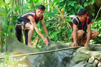 Nước lấy để cúng được hứng trực tiếp từ sông, suối. (Ảnh: Khánh Hòa/TTXVN)