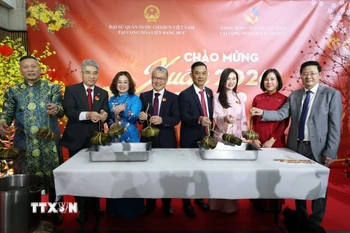 Đại sứ Nguyễn Đắc Thành (thứ2, bên trái), Phu nhân và các vị khách vớt bánh chưng mở đầu buổi lễ. (Ảnh: Thu Hằng/TTXVN)