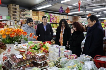 Đại sứ và phu nhân cùng lãnh đạo cộng đồng người Việt tới thăm một cửa hàng bán các sản phẩm truyền thống của Việt Nam tại Trung tâm thương mại Sapa. (Ảnh Việt Thắng/TTXVN)