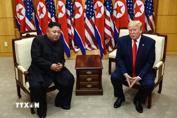 Tổng thống Mỹ Donald Trump (phải) và nhà lãnh đạo Triều Tiên Kim Jong-un trong cuộc gặp ở làng đình chiến Panmunjom tại Khu phi quân sự (DMZ) chiều 30/6/2019. (Ảnh: AFP/TTXVN)