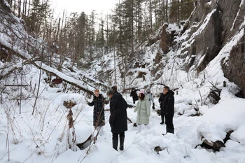 Du khách thích thú chụp ảnh dưới chân Trường Bạch Sơn. (Ảnh: Quang Hưng/TTXVN)