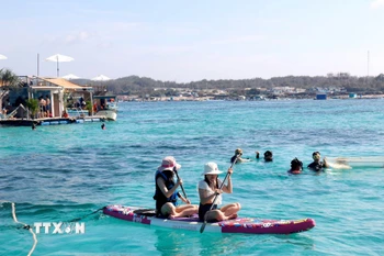 Du khách chèo súp, lặn biển ngắm san hô tại Bãi Cạn, đảo Phú Quý (Bình Thuận). (Ảnh: Nguyễn Thanh/TTXVN)