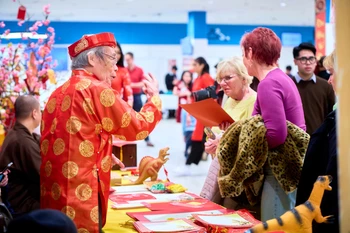 Khách mời tham quan gian hàng viết câu đối trong khuôn khổ chương trình Tết cộng đồng Xuân Bính Ngọ 2026. (Ảnh: TTXVN phát)