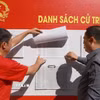 Cử tri phường Nam Nha Trang, tỉnh Khánh Hòa xem danh sách cử tri niêm yết tại khu vực bỏ phiếu bầu cử. (Ảnh: Xuân Triệu/TTXVN)
