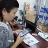 Người dân quét mã để thực hiện các thủ tục hành chính tại Trung tâm phục vụ hành chính công tỉnh Lai Châu. (Ảnh: Việt Dũng/TTXVN)