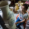 Công đoạn tạo hoa văn cho sản phẩm gốm Bát Tràng. (Ảnh: Trọng Đạt/TTXVN)