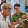 Cán bộ công an hướng dẫn người dân thao tác xin cấp phiếu lý lịch tư pháp trên ứng dụng VNeID. (Ảnh: Mai Trang/TTXVN)