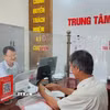 Công chức phường Mạo Khê, Quảng Ninh, hướng dẫn công dân nộp hồ sơ chứng thực lên Cổng dịch vụ công Quốc gia. (Ảnh: Thanh Vân/TTXVN)
