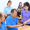 Bà Nguyễn Hoàng Uyên, Phó Giám đốc Sở Y tế Tây Ninh, thăm hỏi, trao quà hỗ trợ các đối tượng bảo trợ xã hội và người khuyết tật. (Ảnh: Thanh Bình/TTXVN)