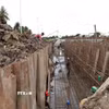 Công trình kè chống sạt lở bờ sông Láng Thé kết hợp khán đài đua ghe Ngo (phường Nguyệt Hóa) đang được đẩy nhanh tiến độ để hoàn thành, đưa vào sử dụng trong tháng 9/2026. (Ảnh: Thanh Hòa/TTXVN)