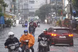 Người dân chật vật dắt xe sau trận mưa lớn ở Thành phố Hồ Chí Minh