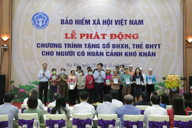 Tặng sổ bảo hiểm xã hội, thẻ bảo hiểm y tế cho người có hoàn cảnh khó khăn. (Ảnh: PV/Vietnam+) 10 dấu ấn nổi bật trong hoạt động của ngành bảo hiểm xã hội năm 2022 ảnh 1