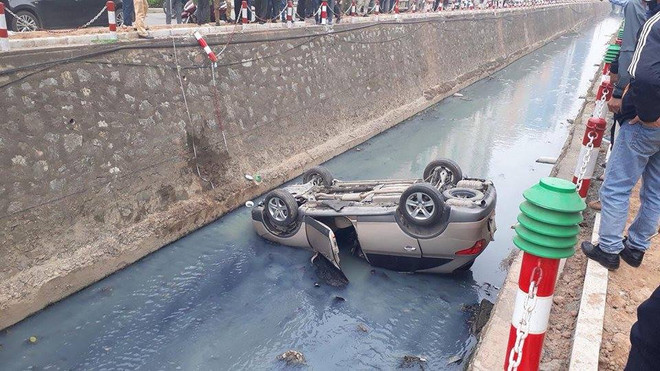 Hà Nội: Xế hộp lao qua dải phân cách, nằm "ngửa bụng" dưới mương ảnh 1