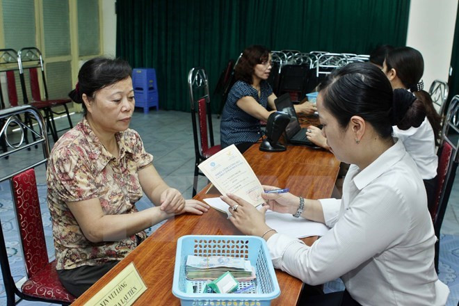 Một điểm chi trả lương hưu, trợ cấp bảo hiểm xã hội. (Ảnh: Minh Quyết/TTXVN) Điều chỉnh sách lương hưu để tránh những "cú sốc" trong tương lai ảnh 1