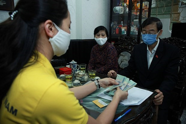 Bưu điện Thành phố Hà Nội chi trả tiền lương hưu tới tận tay người hưởng. (Ảnh minh họa: PV/Vietnam+) Chi trả lương hưu, trợ cấp bảo bảo hiểm tháng 7 và 8 vào cùng một kỳ ảnh 1