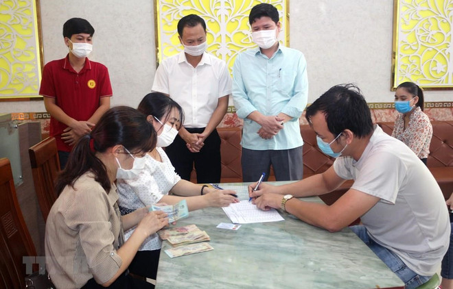 Chi trả tiền hỗ trợ cho người lao động bị ảnh hưởng bởi COVID-19. (Ảnh minh họa: Đại Nghĩa/TTXVN) Địa phương đầu tiên trên cả nước chi tiền hỗ trợ thuê trọ cho lao động ảnh 1