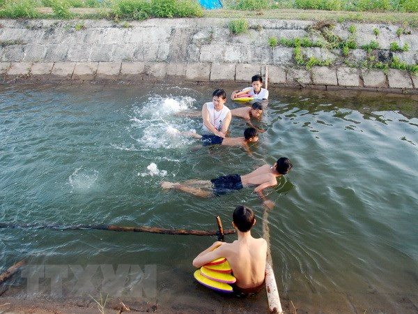 Hướng dẫn trẻ em kỹ năng bơi lội. (Ảnh: Thanh Thủy/TTXVN) Tăng cường các biện pháp phòng, chống đuối nước và xâm hại trẻ em ảnh 1