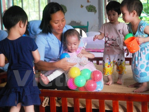 Trẻ em khuyết tật bị bỏ rơi được cán bộ trợ giúp xã hội chăm sóc. Ảnh minh họa. (Ảnh: Hồng Kiều/Vietnam+) Phát triển nghề công tác xã hội: Muốn chuyên nghiệp phải có luật riêng ảnh 1