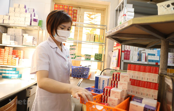 Nhân viên y tế tại bệnh viện sắp thuốc để cấp cho bệnh nhân. (Ảnh minh hoạ: Minh Quyết/Vietnam+) Sửa Luật Đấu thầu sẽ tháo gỡ vướng mắc trong mua thuốc, vật tư y tế ảnh 1