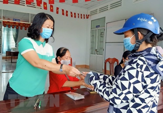 Trao tiền hỗ trợ cho người bán vé số tại thành phố Cần Thơ. (Ảnh: TTXVN) Bộ Lao động đề nghị các địa phương khẩn trương thực hiện Nghị quyết 68 ảnh 1