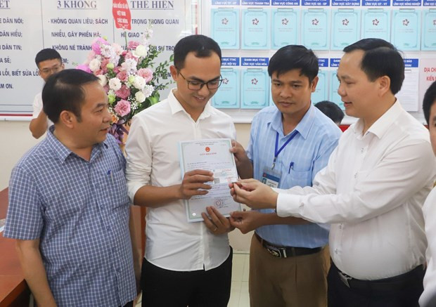 Trao giấy khai sinh và thẻ bảo hiểm y tế theo dịch vụ công liên thông. (Ảnh: PV/Vietnam+) Triển khai cấp giấy khai sinh và thẻ bảo hiểm y tế cùng lúc từ 1/7 ảnh 1