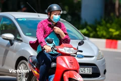 Người dân di chuyển dưới trời nắng gắt. (Ảnh: Hoài Nam/Vietnam+)
