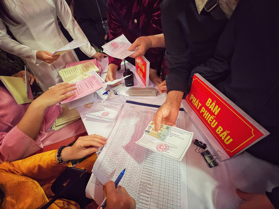 Cử tri xuất trình giấy tờ (CCCD/Thẻ cử tri) tại điểm bầu... (Ảnh: Mai Mai/Vietnam+)