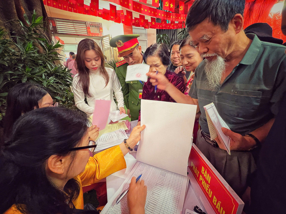 Đại diện các tổ dân phố rà soát, đối chiếu danh sách cử tri trước khi phát phiếu bầu. (Ảnh: Mai Mai/Vietnam+)