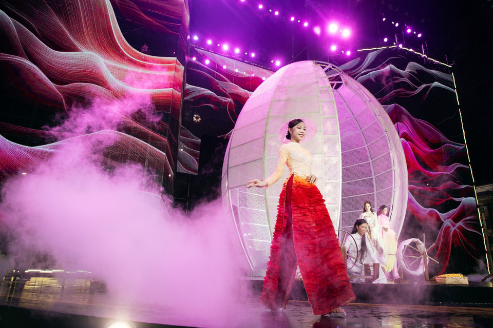 Nghệ nhân Trung Đinh cho biết anh vẫn trung thành với kỹ thuật nhuộm và vẽ thủ công trên lụa để tạo những tác phẩm áo dài có phom dáng truyền thống, thanh lịch và chuẩn mực sang trọng. (Ảnh: CTV/Vietnam+)