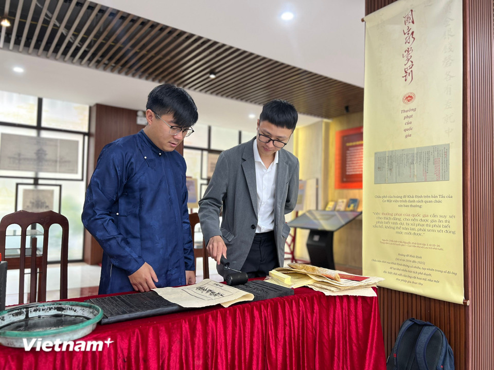 Tại khu vực “Lưu dấu mộc bản” còn giúp công chúng hóa thân thành những “nghệ nhân” khi tự tay thực hiện kỹ thuật in dập mộc bản trên giấy dó. (Ảnh: Mai Mai/Vietnam+)