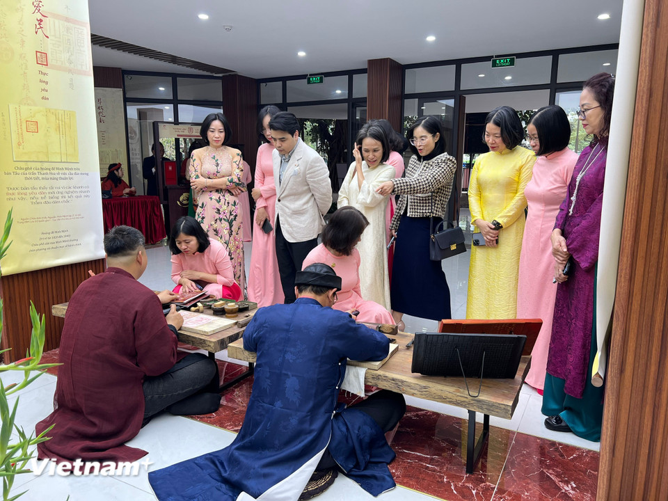 Công chúng tham quan khu vực "Lưu dấu mộc bản." (Ảnh: Mai Mai/Vietnam+)