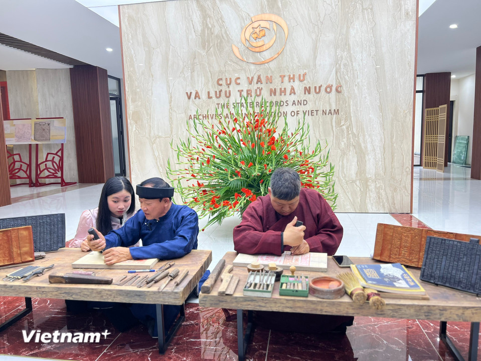 Giới trẻ tìm hiểu về kỹ thuật khắc in mộc bản với nghệ nhân từ làng Thanh Liễu. (Ảnh: Mai Mai/Vietnam+)