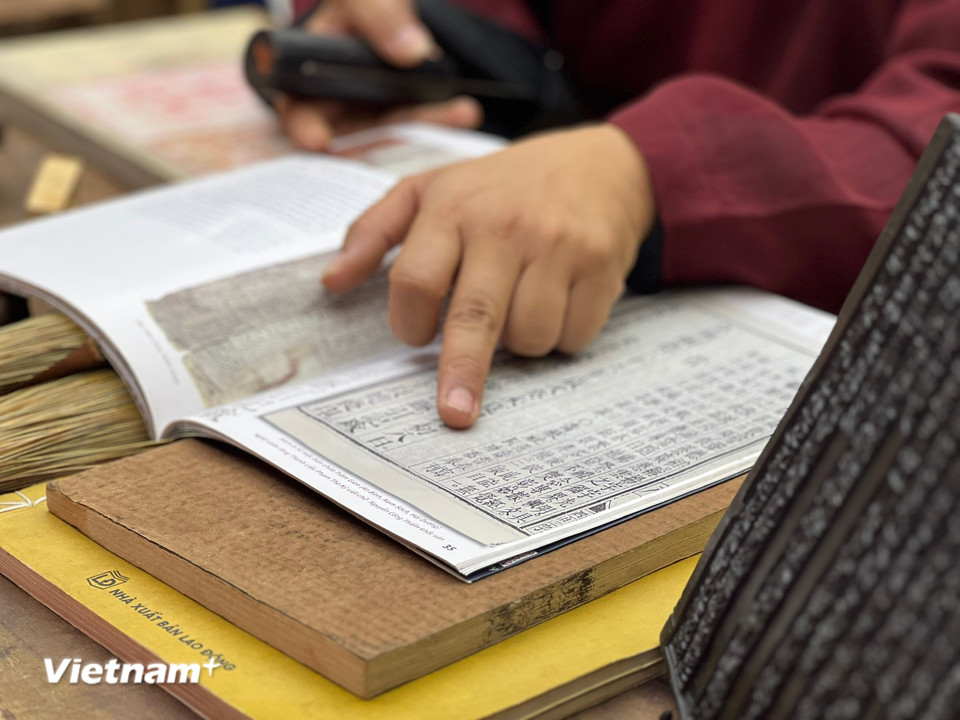 Nghệ nhân làng nghề mộc bản Thanh Liễu giới thiệu về nguồn gốc và hành trình gìn giữ di sản của làng nghề. (Ảnh: Mai Mai/Vietnam+)