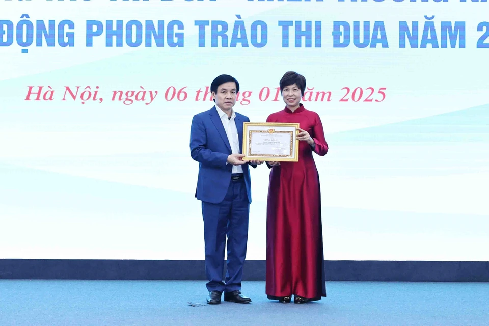 Đồng chí Nguyễn Quang Trường, Phó Bí thư Đảng ủy Khối các cơ quan Trung ương trao Bằng khen Đảng bộ khối các cơ quan Trung Uơng cho đồng chí Vũ Việt Trang, Ủy viên Ban chấp hành Đảng bộ Khối các cơ quan Trung ương, Bí thư Đảng uỷ, Tổng giám đốc Thông tấn xã Việt Nam. (Ảnh: Minh Đức/TTXVN)