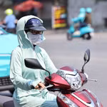 Người dân trang bị chống nắng khi ra đường. (Ảnh: Minh Đức/TTXVN)