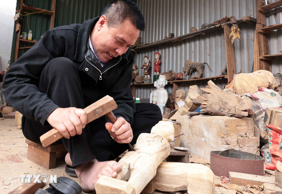Nghệ nhân Nguyễn Văn Phi sớm được tiếp cận với nghề từ khi còn nhỏ, hiện là người duy nhất trong làng làm công việc chế tác rối nước. (Ảnh: Trần Việt/TTXVN)