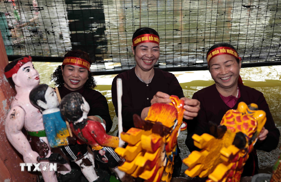 Các nghệ sỹ có "bàn tay vàng" của làng rối Đào Thục luôn khiêm nhường ẩn mình sau bức mành thưa để làm nên bao điều kỳ diệu cho công chúng. (Ảnh: Trần Việt/TTXVN)