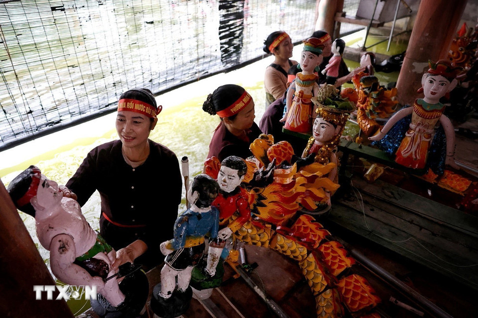 Các nghệ sỹ làng múa rối Đào Thục kỳ công chuẩn bị cho màn biểu diễn rối nước để hóa thân, lột xác cho cuộc đời những con rối. (Ảnh: Phạm Hậu/TTXVN)