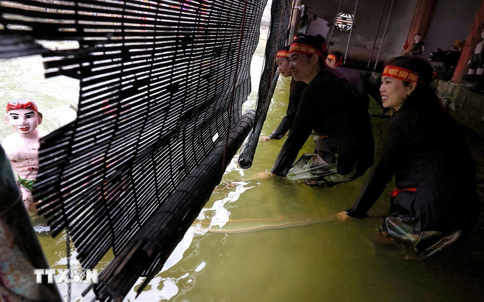 Với nghệ thuật múa rối nước, nghệ sỹ luôn ẩn mình sau bức mành thưa, lặng lẽ, khiêm nhường, chẳng xưng danh, không cân đai áo mũ, mà tất cả chỉ nhờ vào đôi tay tài hoa để mang điều kỳ diệu đến cho công chúng. (Ảnh: Phạm Hậu/TTXVN)