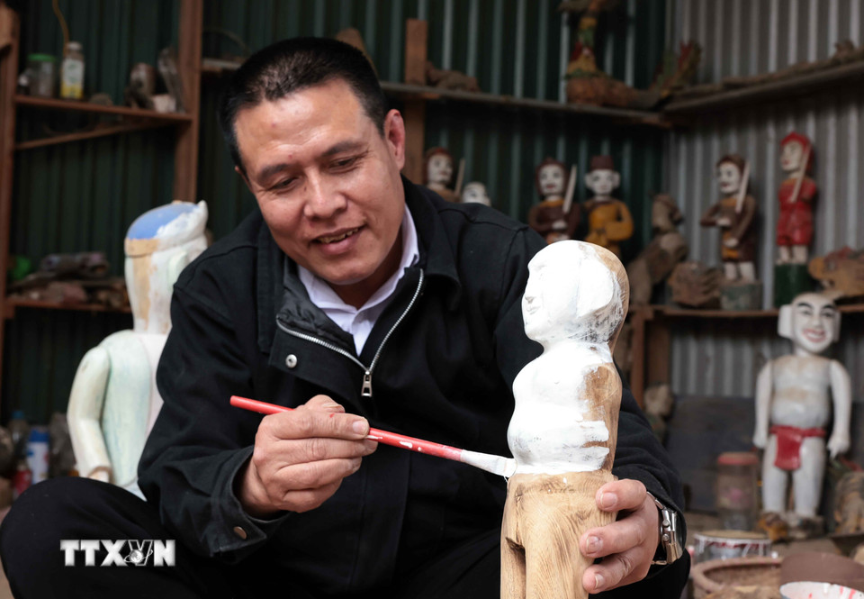 Nghệ nhân Nguyễn Văn Phi sớm được tiếp cận với nghề từ khi còn nhỏ, hiện là người duy nhất trong làng làm công việc chế tác rối nước. (Ảnh: Trần Việt/TTXVN)