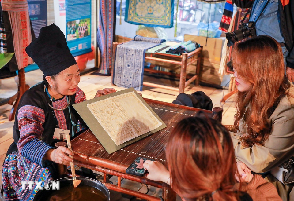 Quy trình vẽ sáp ong thu hút sự quan tâm của nhiều người dân và du khách. (Ảnh: Khánh Hoà/TTXVN)