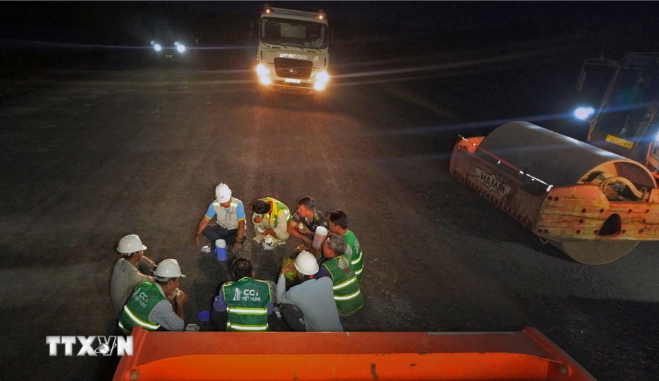 Cán bộ kỹ sư, công nhân tranh thủ ăn vội để quay trở lại làm việc. (Ảnh: Huỳnh Anh/TTXVN)
