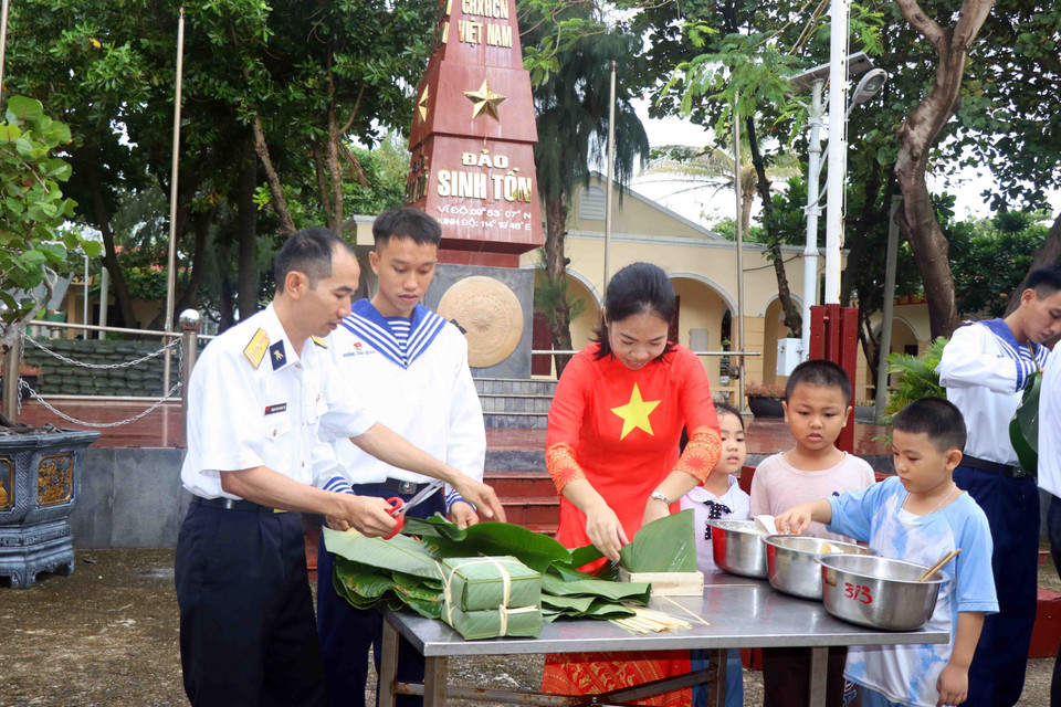 Quân và dân tại đảo Sinh Tồn tham gia gói bánh chưng ngày Tết. (Ảnh: Hữu Quyết/TTXVN)