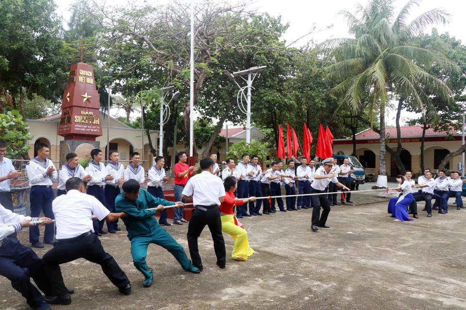 Cán bộ, chiến sỹ và người dân tại đảo Sinh Tồn tham gia trò chơi kéo co. (Ảnh: Hữu Quyết/TTXVN)