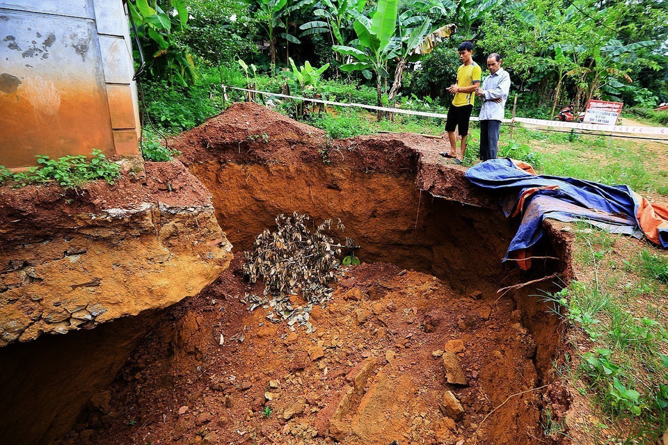 Hố sụt lún làm lộ toàn bộ phần móng và khoét sâu vào bên trong móng nhà kiên cố khoảng 1,5 m. (Ảnh: Trọng Đạt/TTXVN)